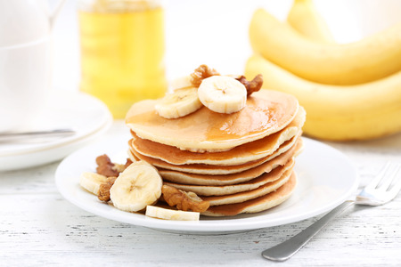 Tasty pancakes with banana and walnut on white wooden backgroundの写真素材