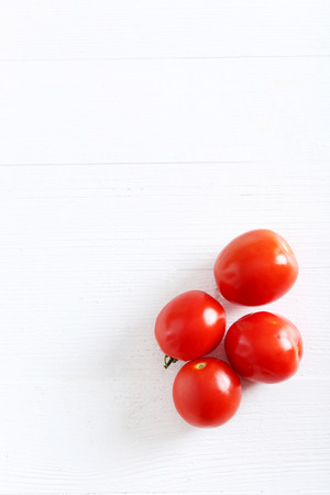 Fresh red tomatoes on white wooden tableの写真素材