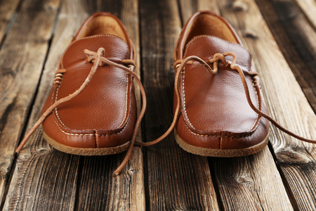 Fashion brown shoes on a brown wooden tableの写真素材
