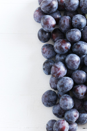 Fresh plums on white wooden backgroundの写真素材