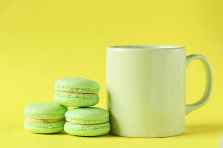 Green macarons on yellow paper backgroundの写真素材