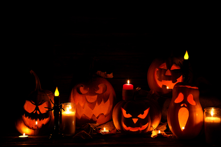 Halloween pumpkins with candle on brown wooden tableの写真素材