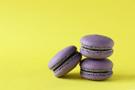 Purple macarons on yellow paper backgroundの写真素材