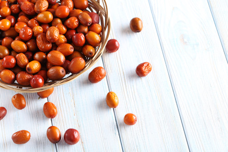Ripe jujubes on blue wooden table, close up