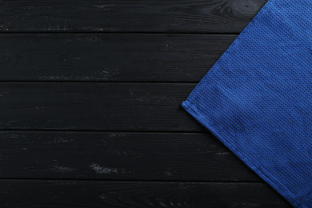 Napkin on black wooden table, close up