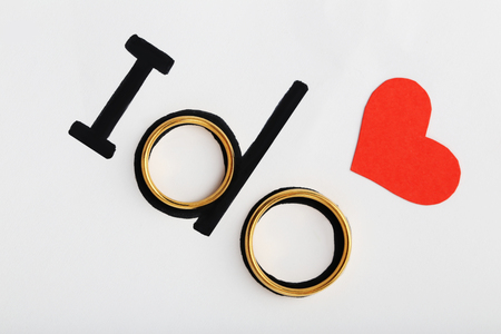 Golden wedding rings with red heart and words I doの写真素材