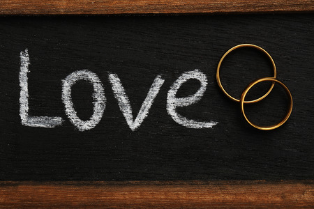 Golden wedding rings on the wooden frameの写真素材