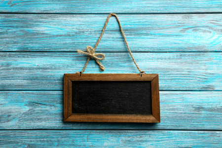 Brown wooden frame on blue wooden tableの写真素材