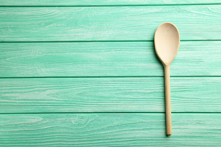 Wooden spoon on a mint wooden tableの写真素材