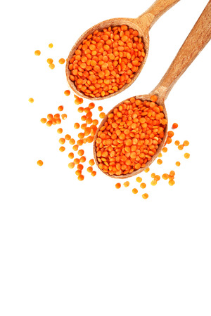 Red lentils in the wooden spoons on a white backgroundの写真素材