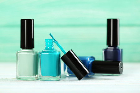 Bottles of nail polish on a wooden tableの写真素材