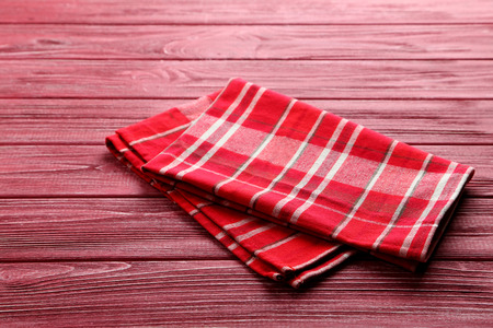 Napkin on red wooden table, close up