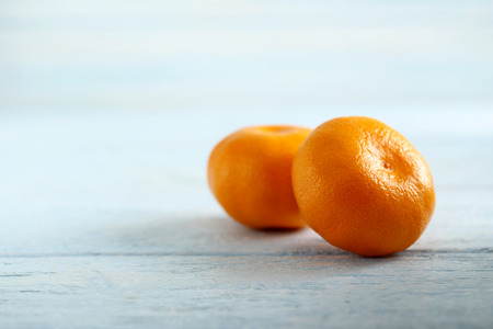 Ripe mandarins on a blue wooden tableの写真素材