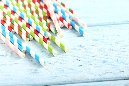 Striped drink straws on a blue wooden backgroundの写真素材