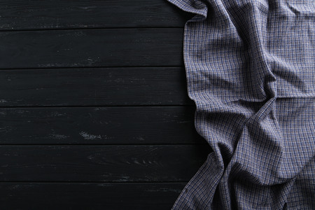 Napkin on black wooden table, close up