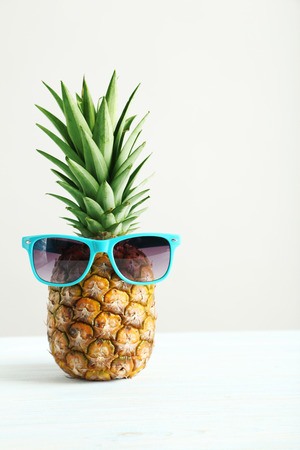 Ripe pineapple on a white wooden tableの写真素材