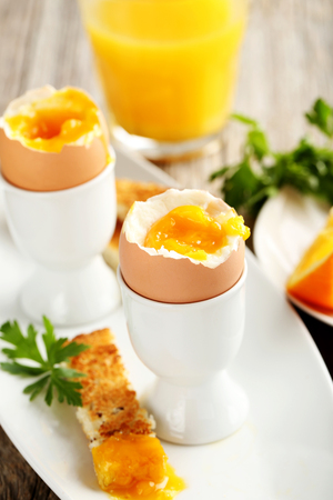 Boiled egg with toasts on a grey wooden tableの写真素材