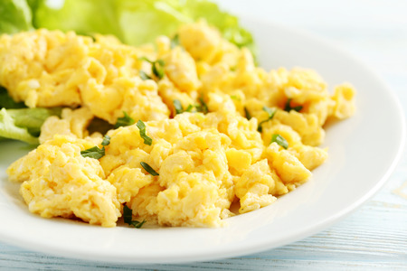 Scrambled eggs with vegetables on a blue wooden tableの写真素材
