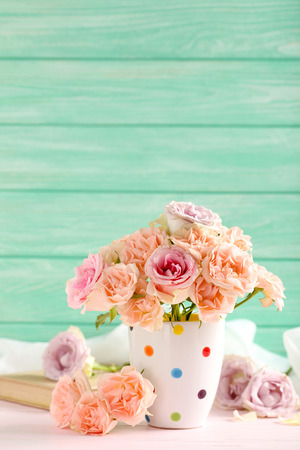 Bouquet of beautiful roses on a pink wooden tableの写真素材