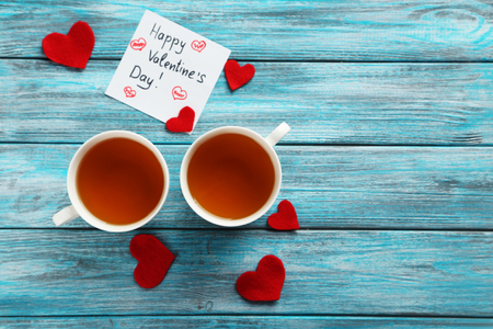 Love hearts with cups of tea on a blue wooden tableの写真素材