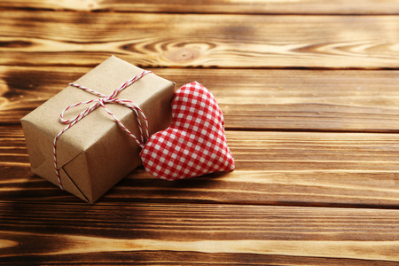 Love heart with gift box on a brown wooden tableの写真素材