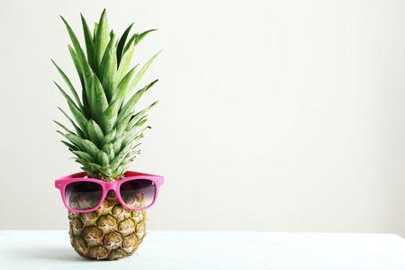 Ripe pineapple on a white wooden tableの写真素材
