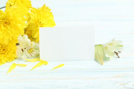 Yellow chrysanthemum flowers on a white wooden tableの写真素材