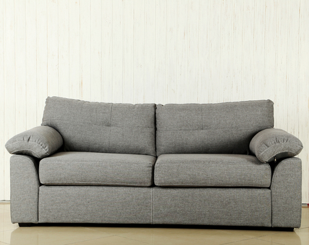 Grey sofa on a white wood wall texture backgroundの写真素材
