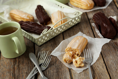 Sweet eclairs on a grey wooden table