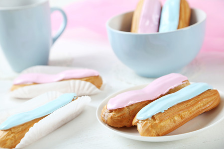 Eclairs with glaze on a white wooden tableの写真素材