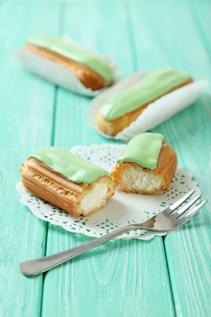Eclairs with glaze on a mint wooden tableの写真素材
