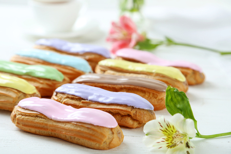 Eclairs with glaze on a white wooden tableの写真素材