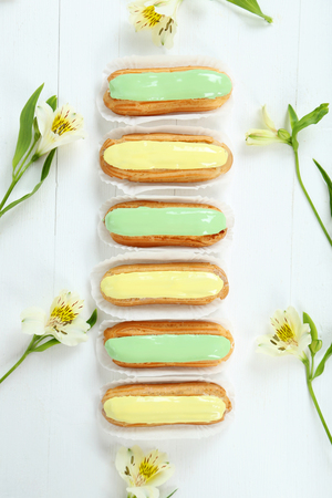 Eclairs with glaze on a white wooden tableの写真素材