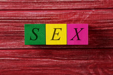 Colorful wooden toy cubes on a red wooden backgroundの写真素材