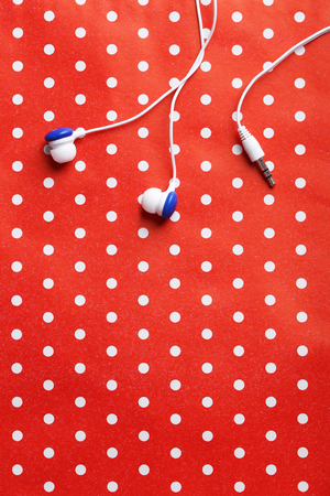 White headphones on a red paper backgroundの写真素材