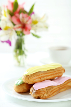 Eclairs with glaze on a white wooden tableの写真素材