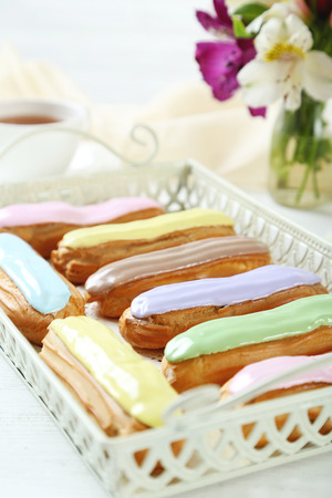 Eclairs with glaze on a white wooden tableの写真素材