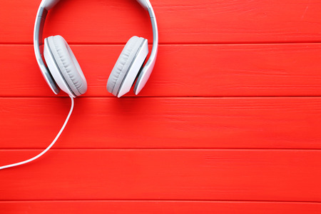 Headphones on a red wooden table, close upの写真素材