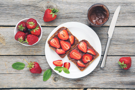 French toasts with chocolate and strawberry on wooden tableの写真素材