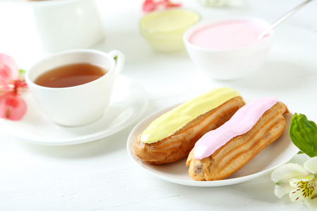 Eclairs with glaze on a white wooden tableの写真素材