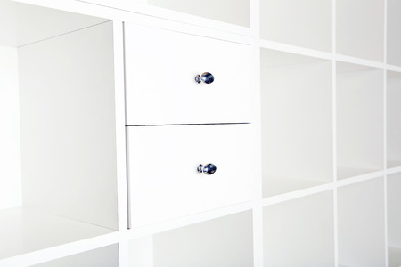 Empty shelves in white wooden rack, close upの写真素材