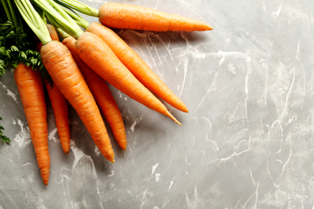 Fresh and sweet carrots on a grey tableの写真素材