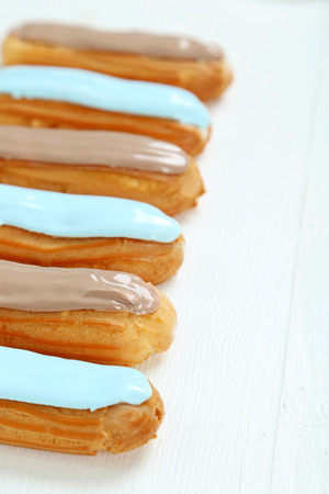 Eclairs with glaze on a white wooden tableの写真素材
