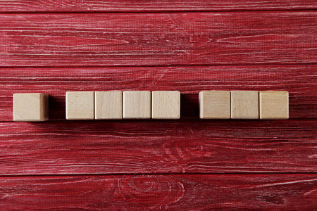 Wooden toy cubes on a red wooden tableの写真素材