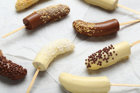 Banana covered in chocolate on a pergamentの写真素材