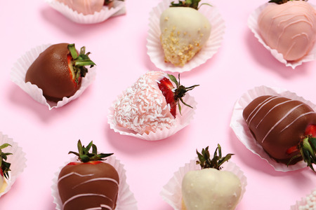 Strawberries covered in chocolate on a pink backgroundの写真素材