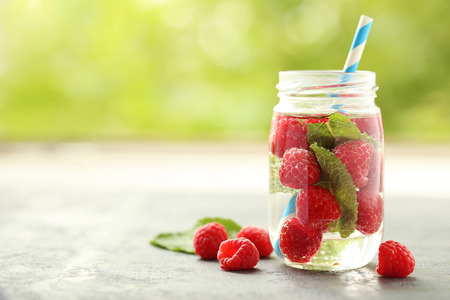 Detox water in bottle with berries on wooden tableの写真素材