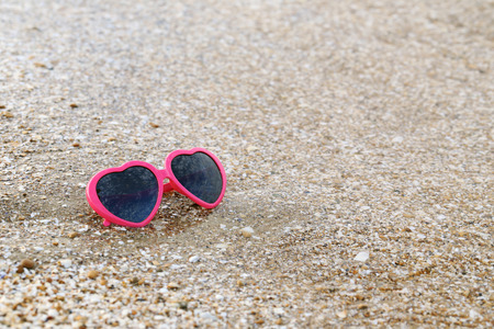 Pink sunglasses on the beach sandの写真素材