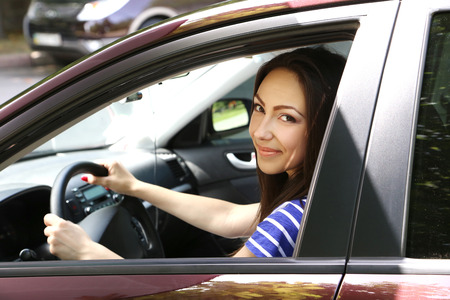 Beautiful young girl sitting in new car