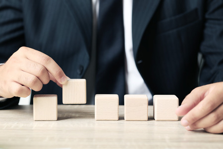 Businessman holding wooden cube in his hand